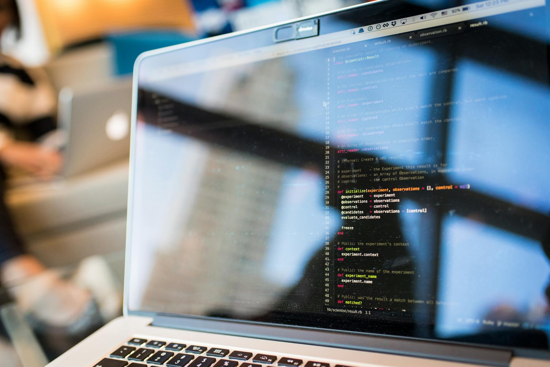 Laptop z wyświetlonym kodem programistycznym odbijającym się w ekranie