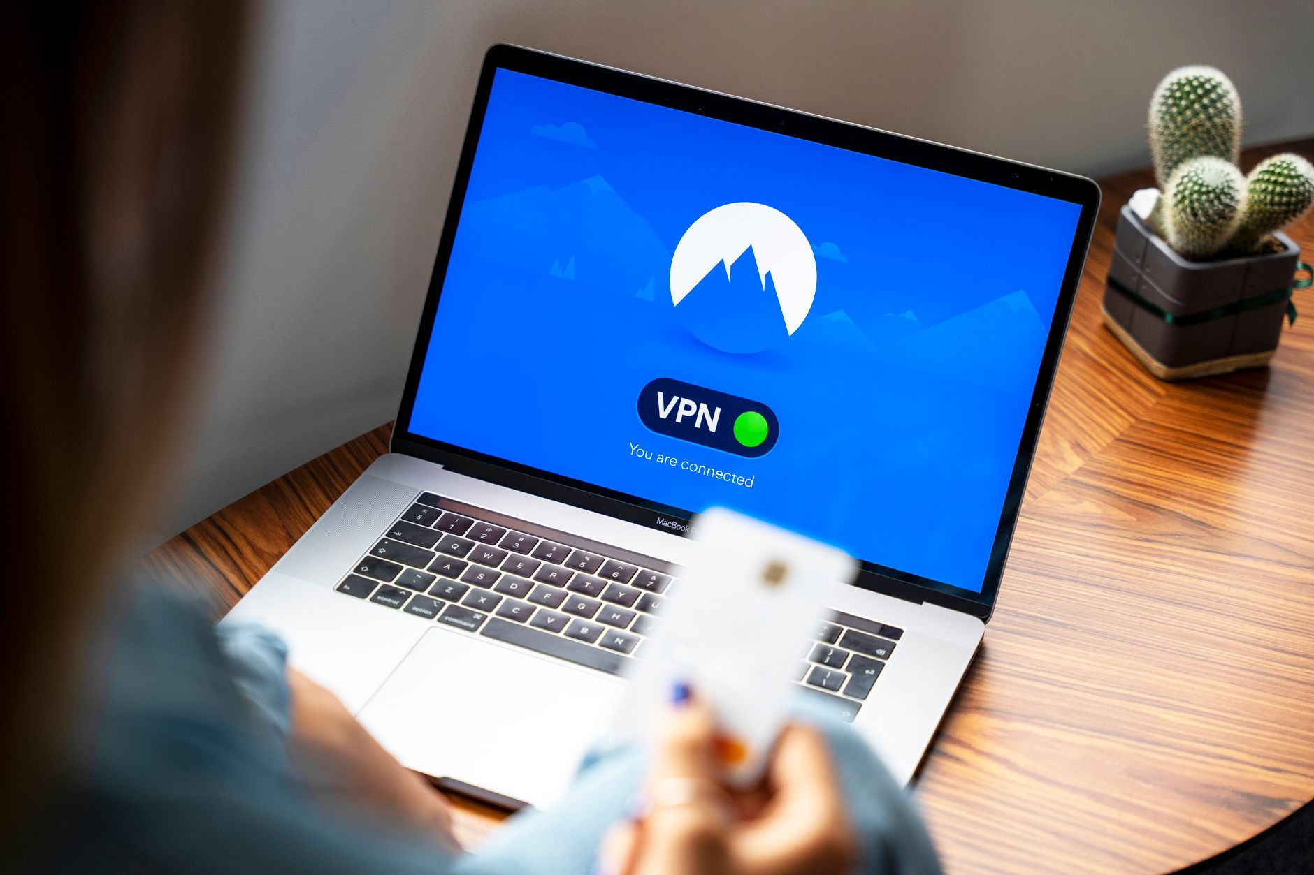 Osoba korzystająca z VPN na laptopie w nowoczesnym biurze